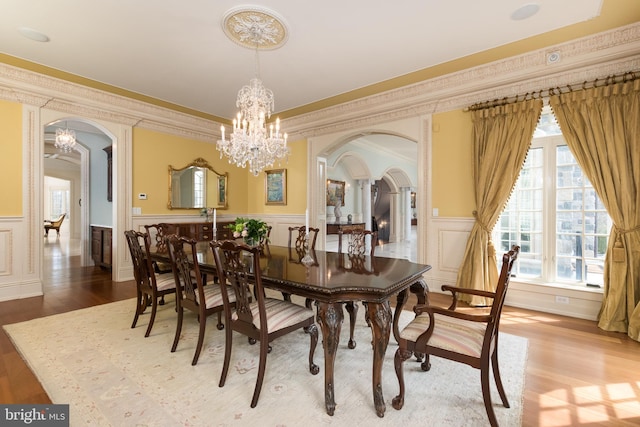 dining space featuring hardwood / wood-style floors, crown molding, and a chandelier