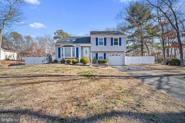 tri-level home featuring a front yard and a garage