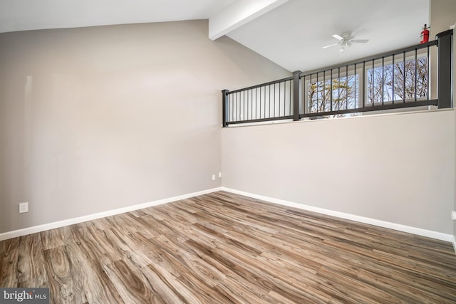 unfurnished room with ceiling fan, wood-type flooring, and lofted ceiling with beams