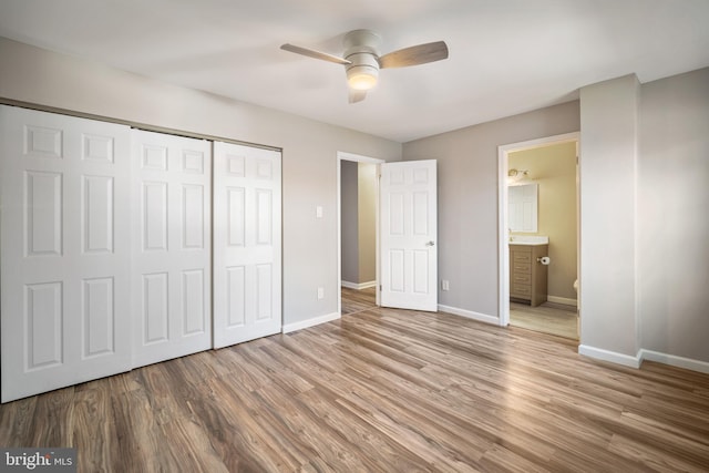 unfurnished bedroom featuring ceiling fan, a closet, ensuite bathroom, and light hardwood / wood-style floors