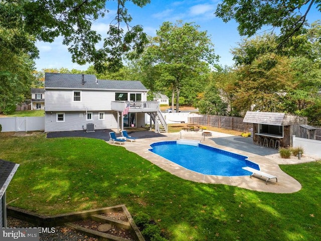 view of swimming pool featuring a patio area, exterior bar, a deck, and a yard