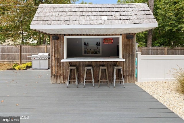 wooden terrace with exterior bar and grilling area