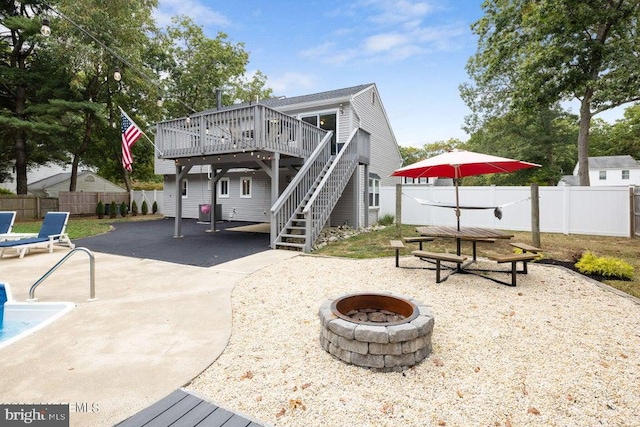 rear view of property featuring an outdoor fire pit, a patio area, and a deck