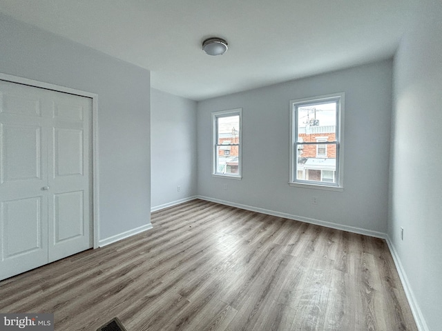 unfurnished bedroom with a closet and light hardwood / wood-style flooring