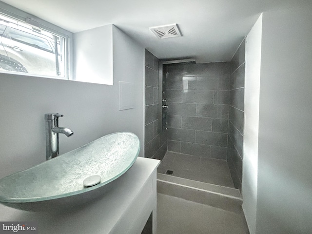 bathroom with sink and a tile shower