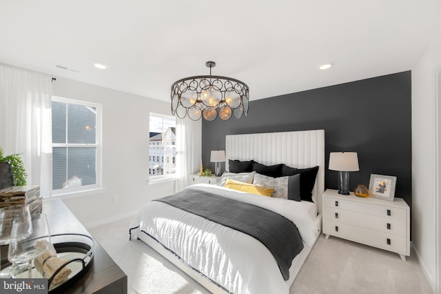 bedroom with light carpet and a notable chandelier