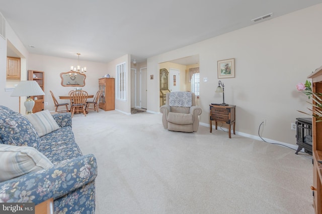 carpeted living room featuring an inviting chandelier