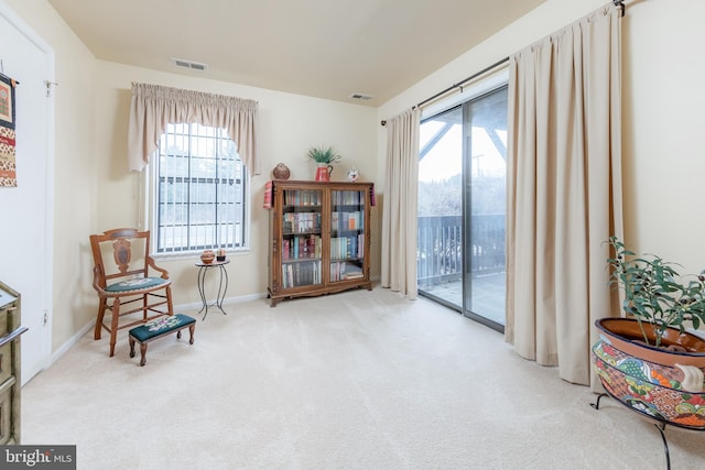 sitting room featuring light carpet and plenty of natural light