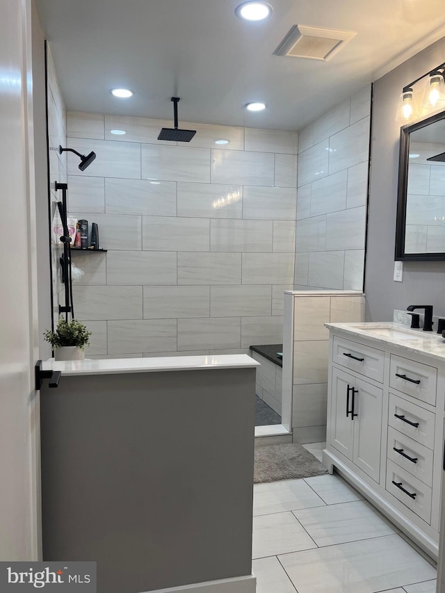 bathroom with vanity, tile walls, a shower, and tile patterned floors