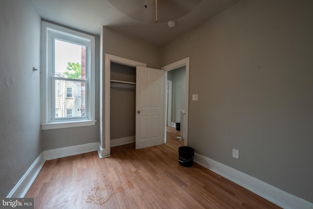 unfurnished bedroom with a closet and light wood-type flooring