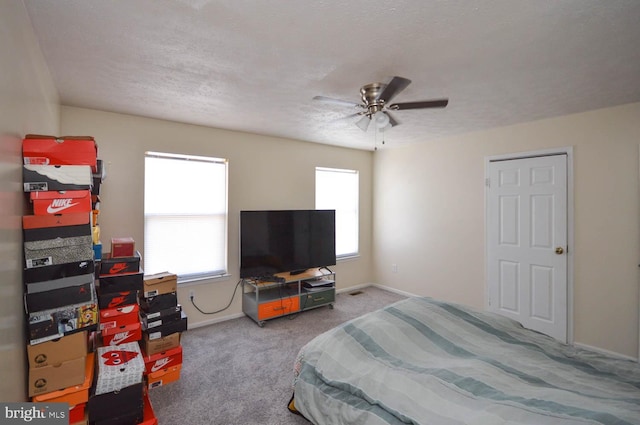 bedroom with a textured ceiling, ceiling fan, and carpet