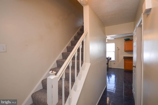 stairs featuring tile patterned flooring and a textured ceiling