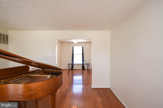 interior space featuring hardwood / wood-style flooring and a textured ceiling