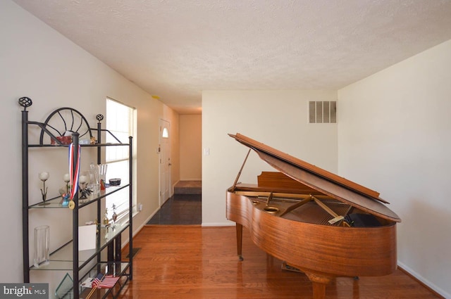 miscellaneous room featuring a textured ceiling and wood-type flooring