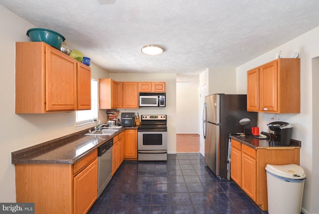 kitchen featuring sink, a textured ceiling, and appliances with stainless steel finishes