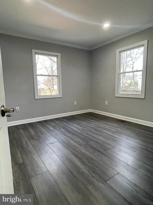 empty room featuring crown molding and dark wood-type flooring