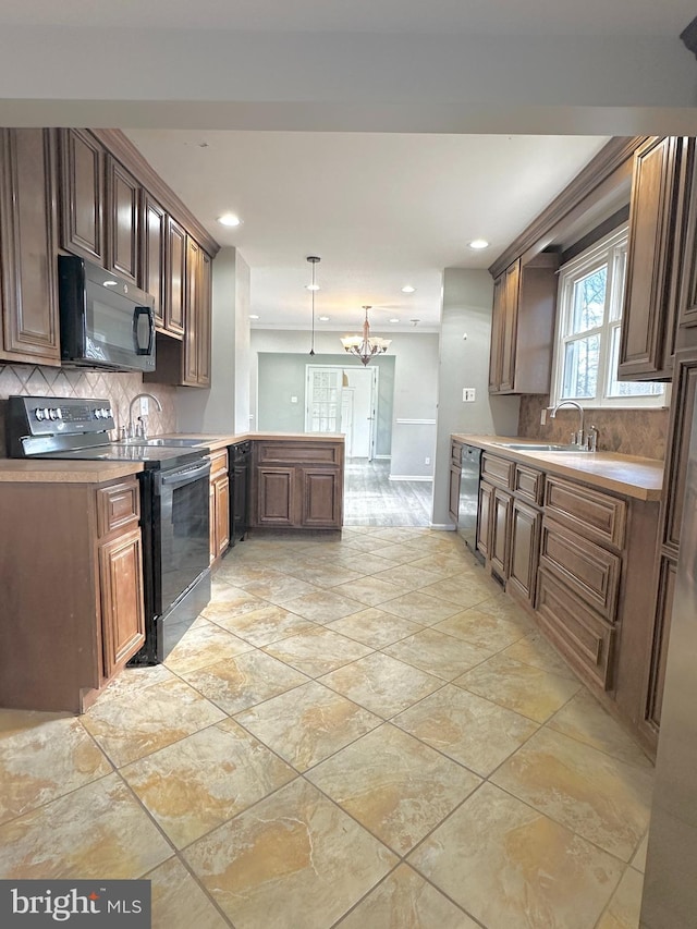 kitchen with sink, decorative backsplash, hanging light fixtures, black appliances, and an inviting chandelier