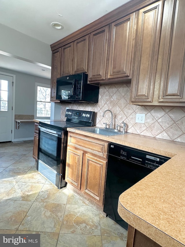 kitchen featuring backsplash, sink, and black appliances