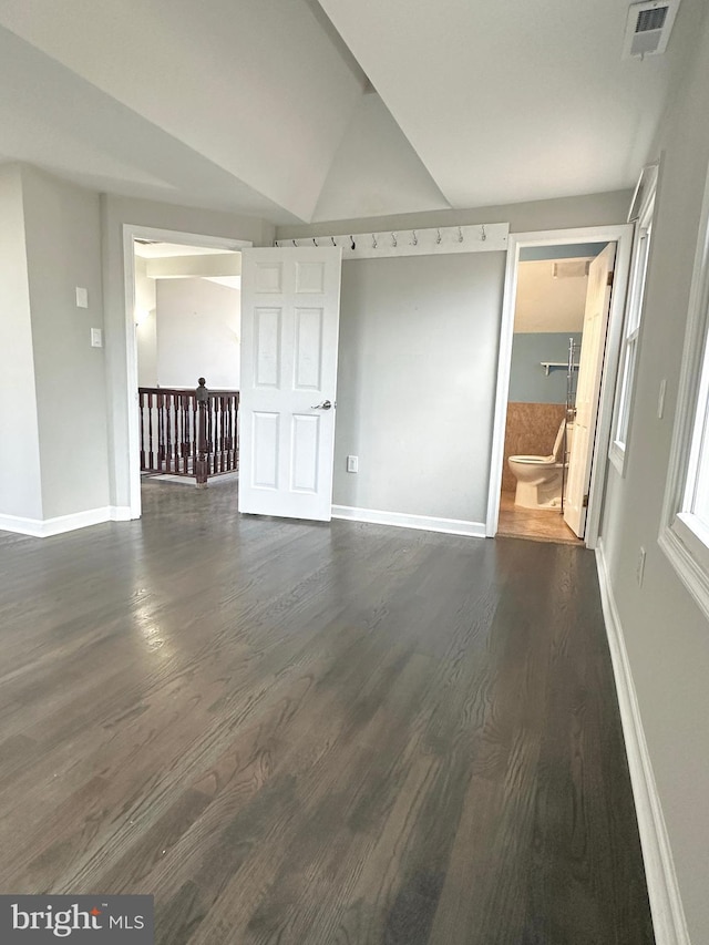 empty room with lofted ceiling and dark hardwood / wood-style flooring