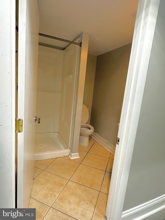 bathroom featuring a shower, tile patterned floors, and toilet