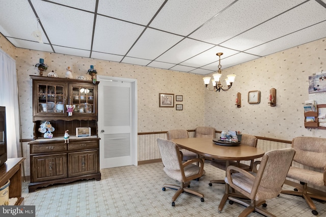 dining room featuring a drop ceiling and a chandelier