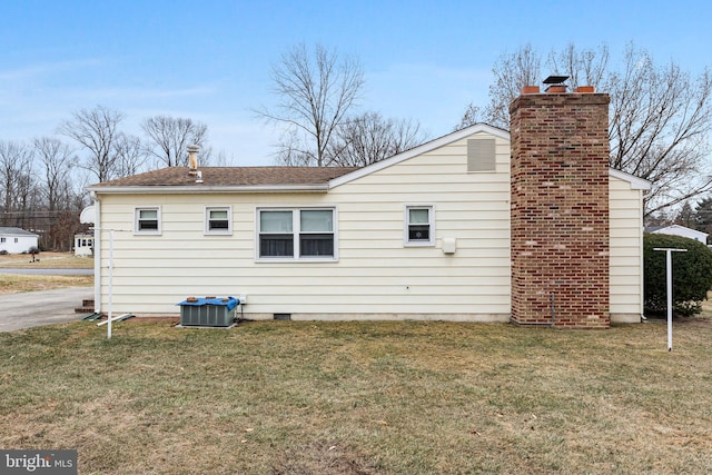 back of property with a lawn and central air condition unit