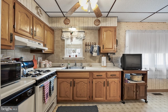 kitchen with ceiling fan, sink, white appliances, and a paneled ceiling