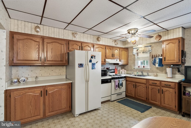 kitchen with ceiling fan, sink, white appliances, and a drop ceiling