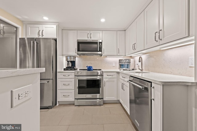 kitchen featuring sink, white cabinetry, light tile patterned floors, stainless steel appliances, and backsplash