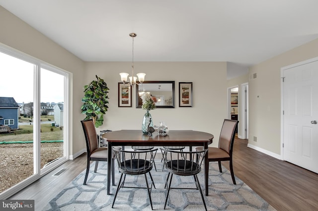 dining area with hardwood / wood-style flooring and a chandelier