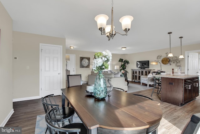 dining space featuring dark hardwood / wood-style floors and an inviting chandelier