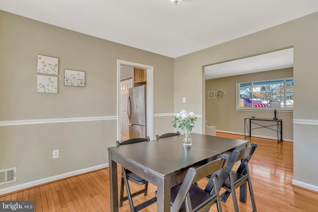 dining space with wood-type flooring