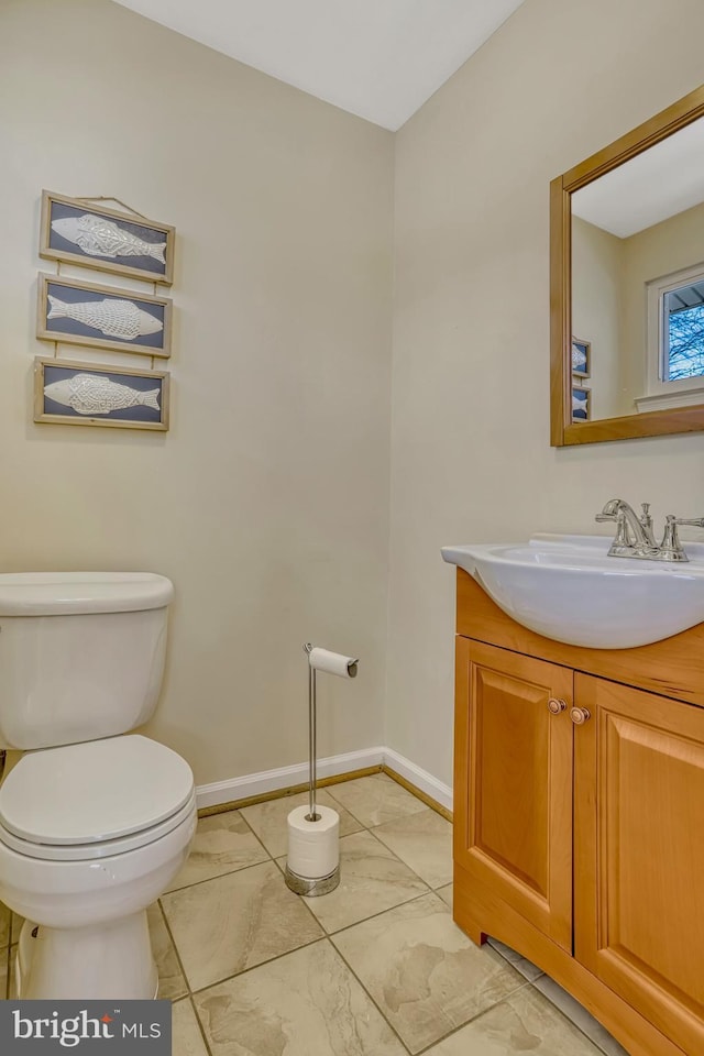 bathroom featuring toilet, vanity, and tile patterned flooring