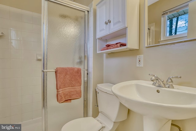 bathroom with toilet, walk in shower, and sink