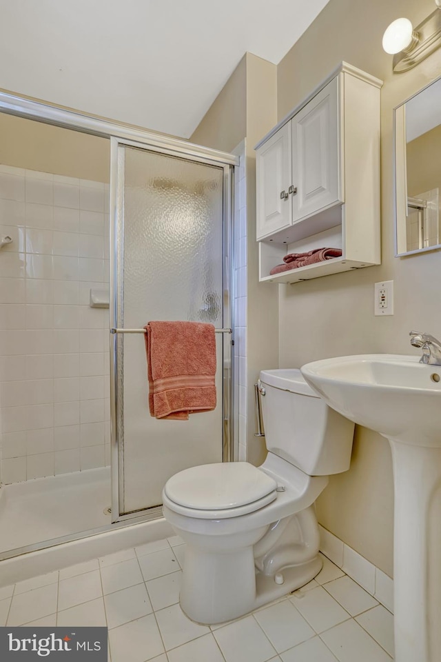 bathroom with toilet, an enclosed shower, and tile patterned floors