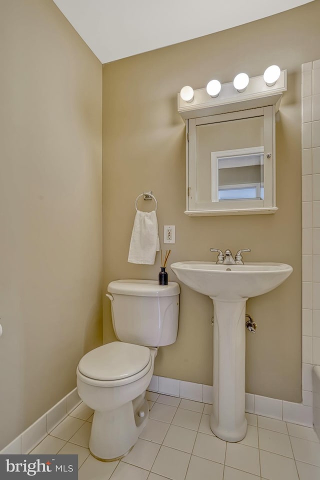 bathroom featuring toilet, sink, and tile patterned floors