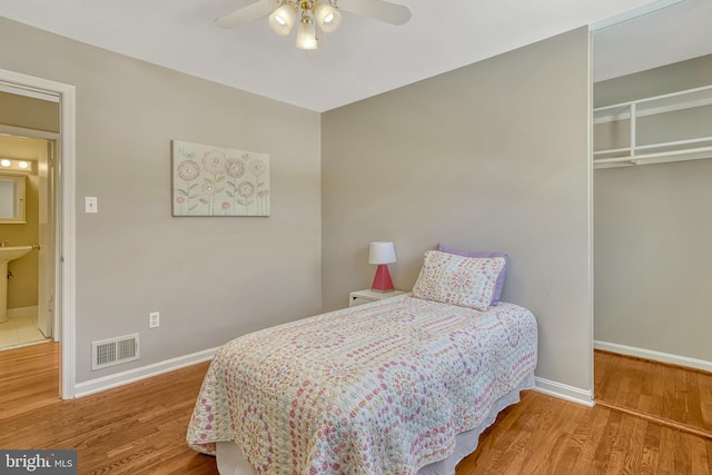 bedroom featuring ceiling fan, wood-type flooring, and a closet