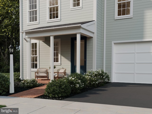view of exterior entry featuring a porch and an attached garage