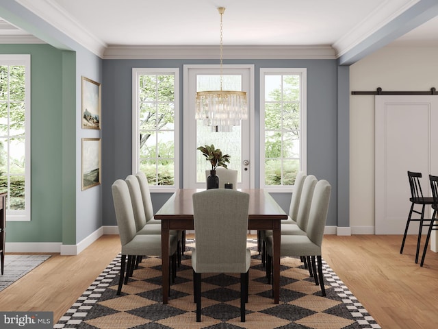 dining room with a barn door, ornamental molding, and a wealth of natural light