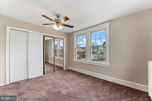 unfurnished bedroom featuring ceiling fan and dark carpet