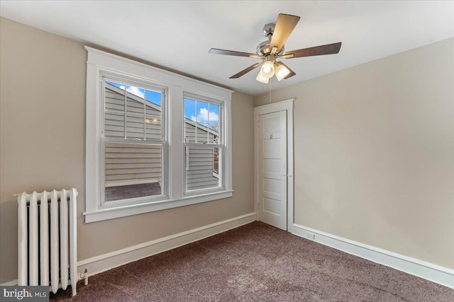 carpeted spare room with ceiling fan and radiator heating unit