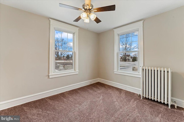 unfurnished room featuring ceiling fan, radiator heating unit, a healthy amount of sunlight, and carpet flooring