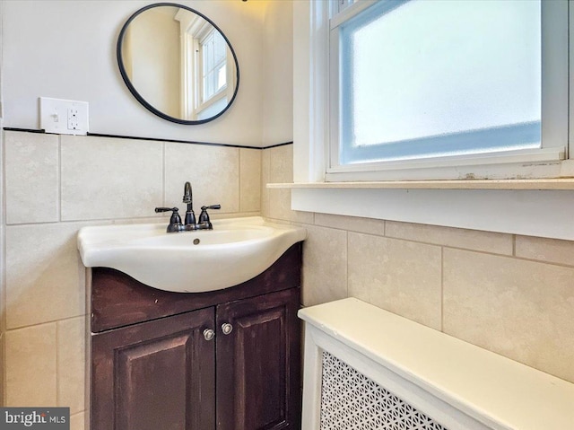 bathroom featuring vanity and tile walls