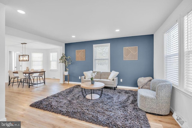 living room with a wealth of natural light and light hardwood / wood-style flooring