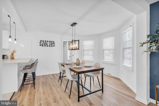 dining area with a chandelier and light hardwood / wood-style floors