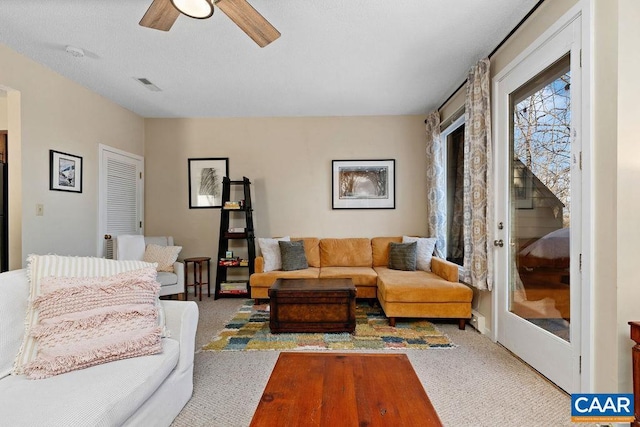 carpeted living room with ceiling fan