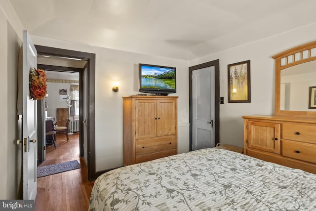 bedroom featuring dark hardwood / wood-style flooring and radiator