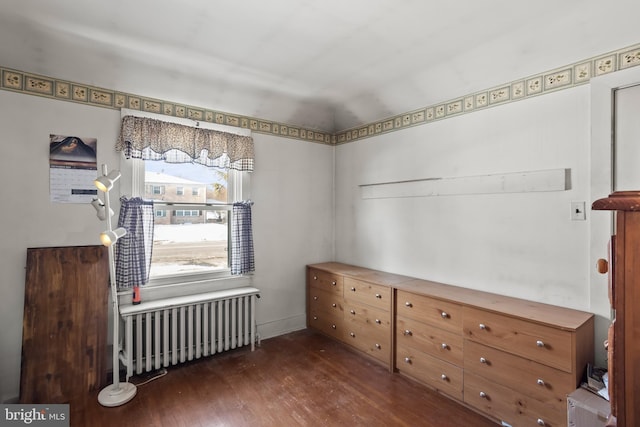 unfurnished room featuring radiator and dark wood-type flooring