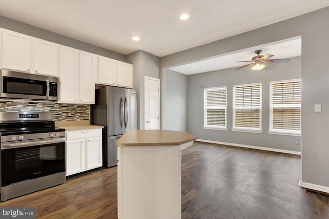 kitchen featuring tasteful backsplash, white cabinetry, dark hardwood / wood-style flooring, ceiling fan, and stainless steel appliances