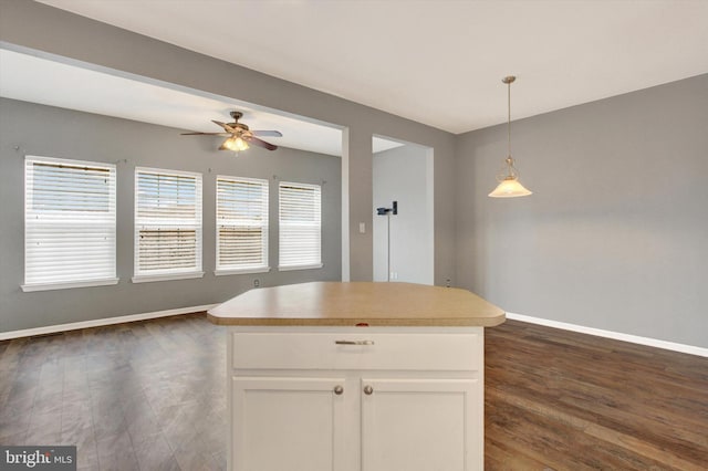 kitchen with a kitchen island, dark hardwood / wood-style floors, decorative light fixtures, white cabinetry, and ceiling fan